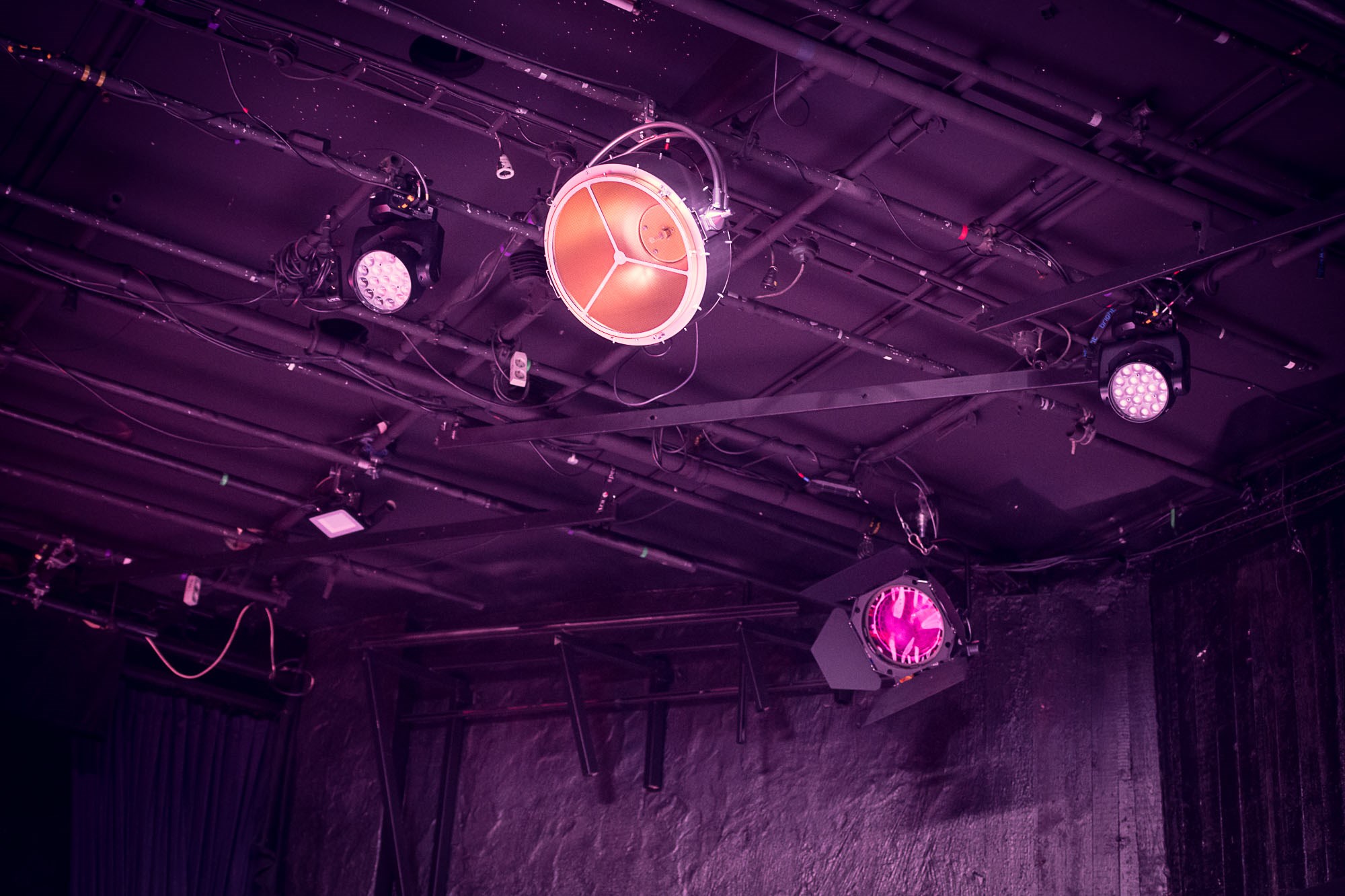 Taket och hela rummet är upplyst i lila. En strålkastare står i fokus som brinner i lätt rosa ljus. 