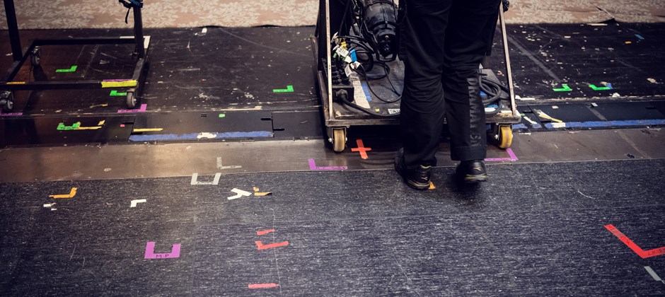 Mörk scenmatta är täckt med markeringstejpbitar Mörk scenmatta är täckt med markeringstejpbitar