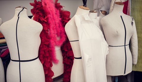 Det står fyra oklädda provdockor bredvid varandra i en grupp varav en har en röd fluffig halsduk runt halsen.