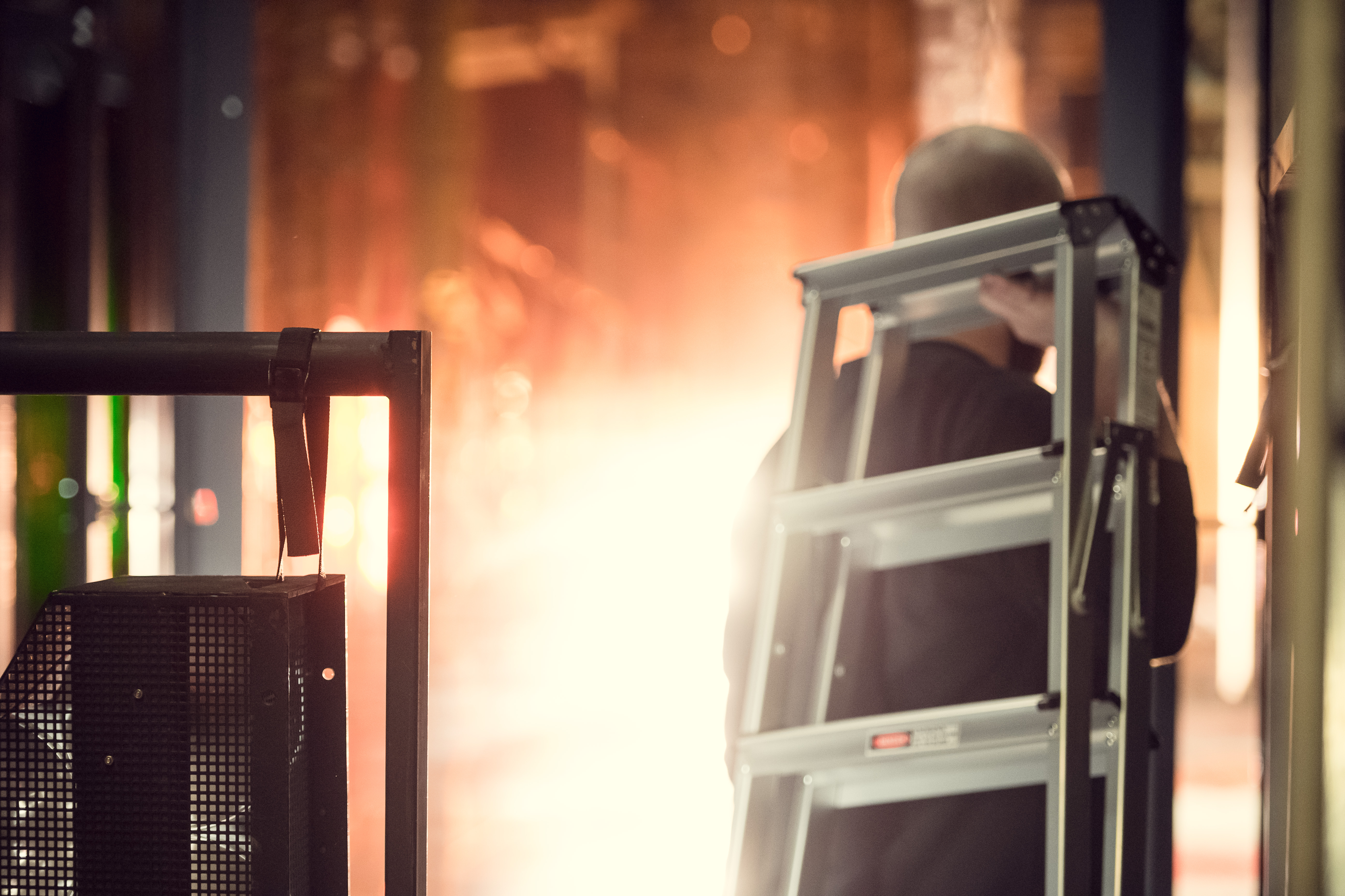 Man bär på en stege på ryggen över scenen.