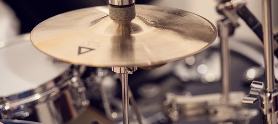 Bilden fokuserar på en cymbal i ett trumset. Bilden fokuserar på en cymbal i ett trumset.