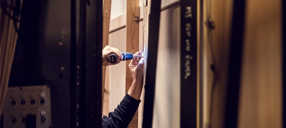 Snickare som sätter upp en tavla på en vägg.  Snickare som sätter upp en tavla på en vägg.