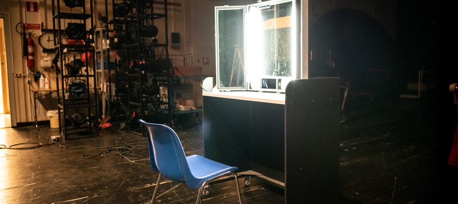 Stol står framför ett sminkbord. Lamporna runt spegeln lyser starkt. Stol står framför ett sminkbord. Lamporna runt spegeln lyser starkt.